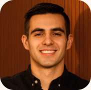 A smiling Brandlight AI visibility expert in a dark shirt, against a wood-panelled wall.