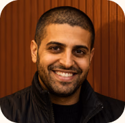A smiling, bearded Brandlight AI visibility expert in a black jacket, against a wood-panelled wall.